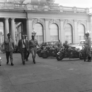 Brizola acompanhado de oficiais da brigada no estacionamento de um prédio.