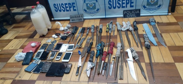 Policiais e presos no pátio do presídio
