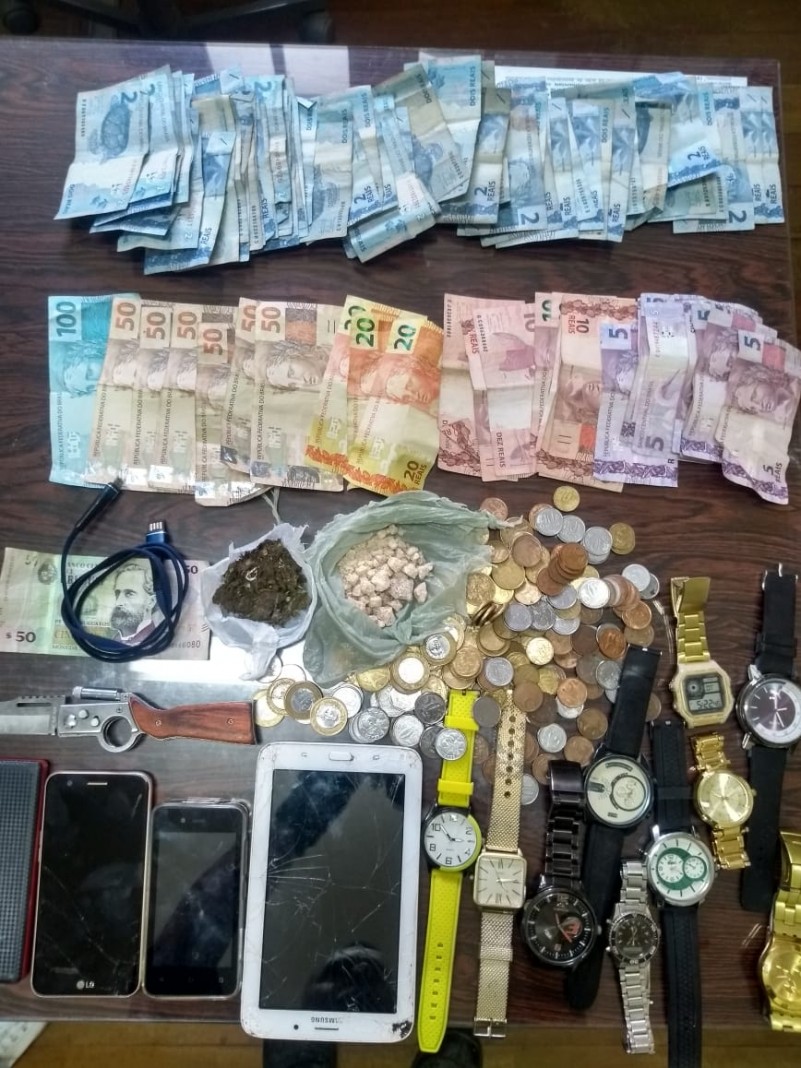 Diversos materiais apreendidos, drogas, relógios, celulares, dinheiro.