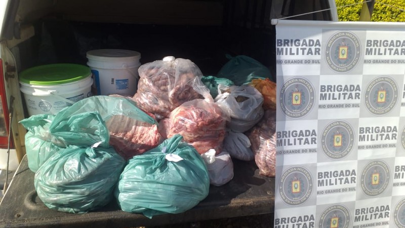 Material apreendido com o banner da brigada militar ao lado