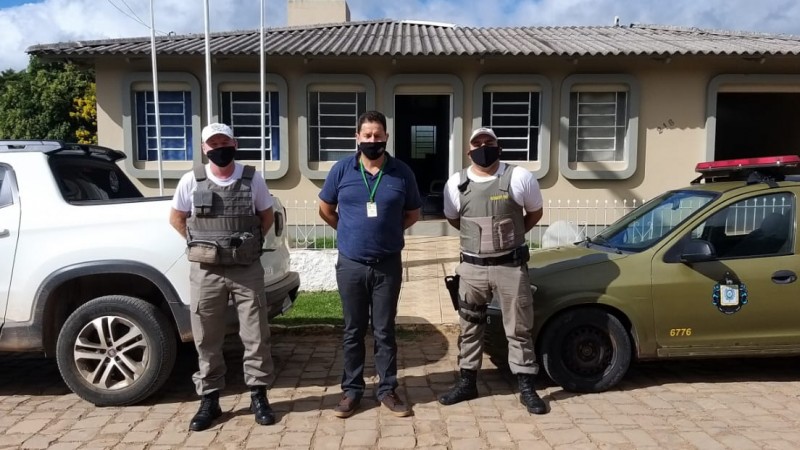 Dois policiais militares e um agente da vigilancia santit&aacute;ria de Lago&atilde;o na frente de duas viaturas e ao fundo o quartel da Brigada Militar,