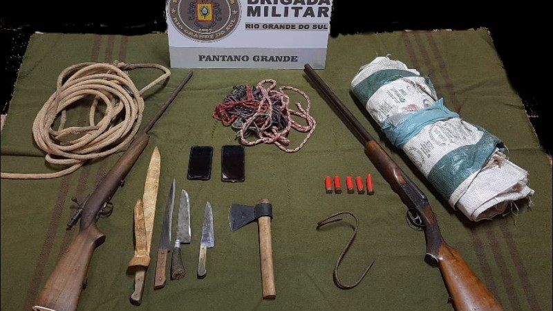 Ao fundo o s&iacute;mbolo da Brigada Militar e na frente os materiais apreendidos.