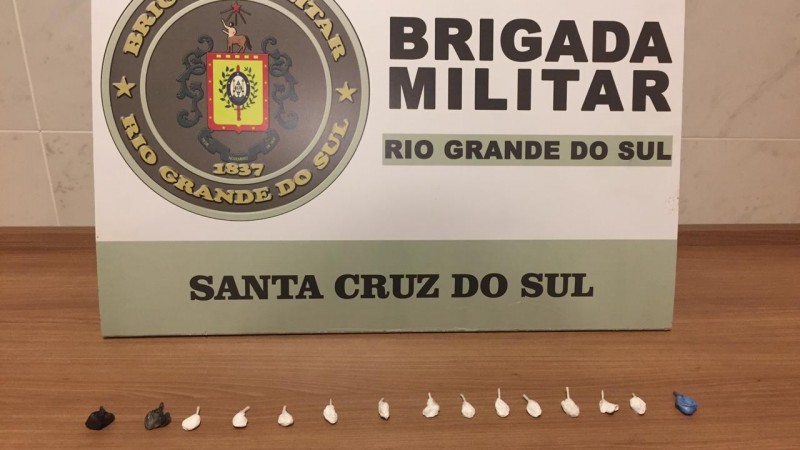 Quinze por&ccedil;&otilde;es fracionadas de droga e atr&aacute;s o banner institucional de Brigada Militar de Santa Cruz do Sul