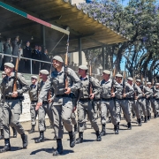 Soldados marchando em fila durante um dia ensolarado.