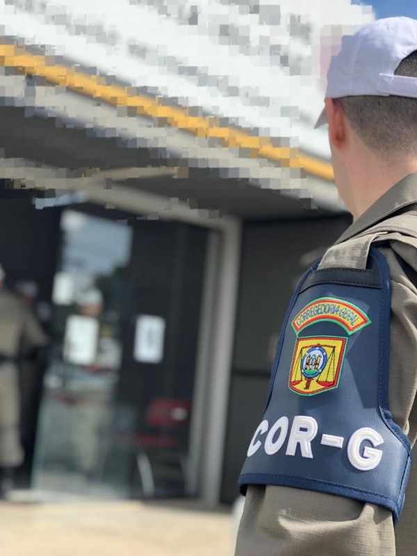 Foto mostra policial militar de costas com destaque para o bracelete da Corregedoria-Geral da Brigada Militar