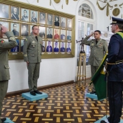 Quatro militares estão parados frente a frente em um salão do quartel