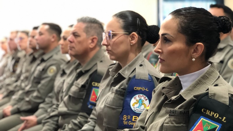 Militares estão sentados lado a lado, durante formatura.