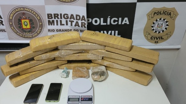 Imagem mostra tabletes de maconha, pedra grande de crack, balança de precisão e celulares dispostos em cima de uma mesa