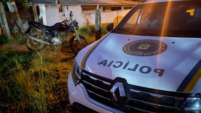 Foto de uma viatura da BM e da motocicleta recuperada.