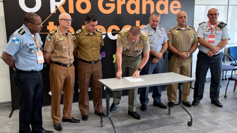 Foto mostra sete comandantes-gerais das PMs do Sul e Sudeste em frente a uma mesa, com assinatura de um documento.