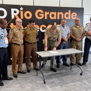Foto mostra sete comandantes-gerais das PMs do Sul e Sudeste em frente a uma mesa, com assinatura de um documento.
