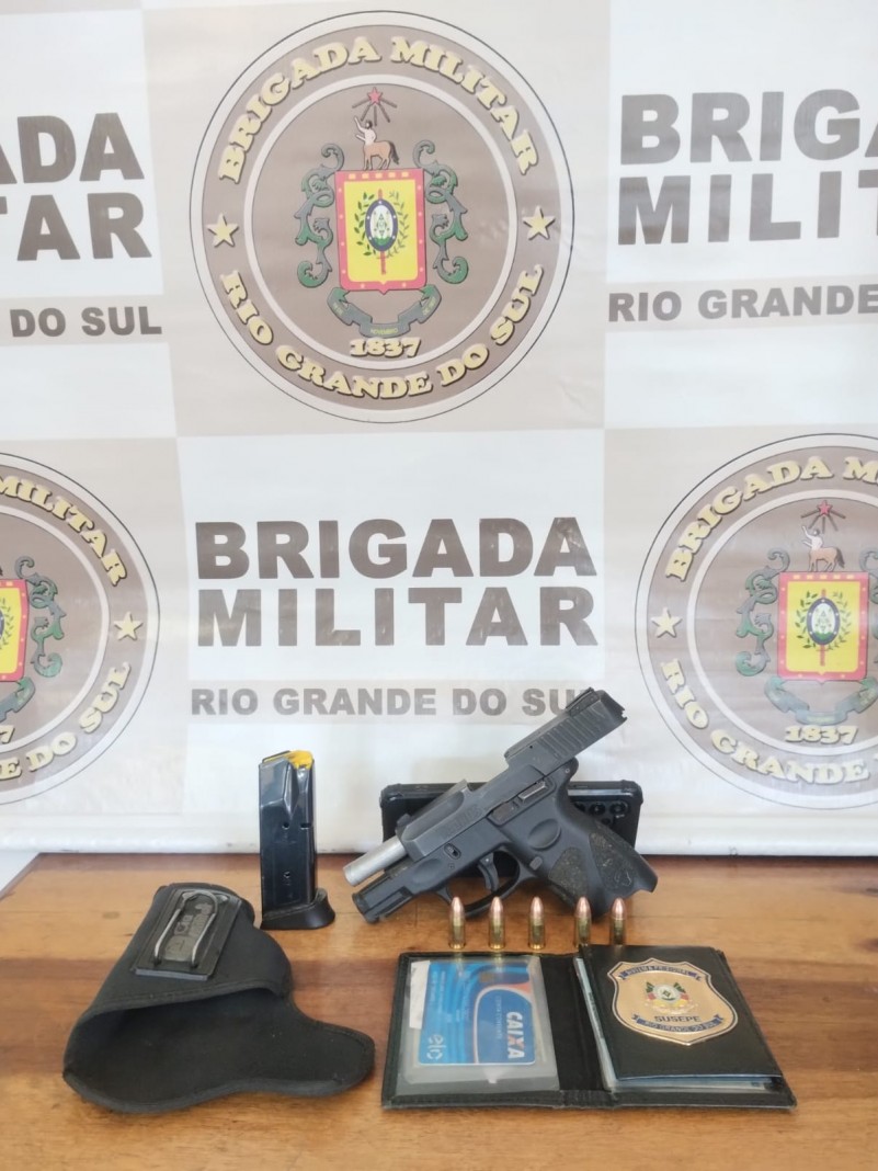 Materialidade apreendida - na imagem, arma de fogo e munições, além de um carregador, um coldre e uma carteira com documentos