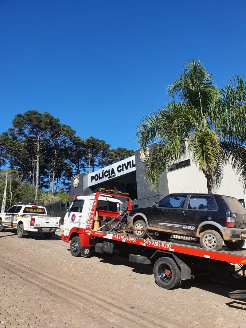 Na foto cont&eacute;m uma viatura e atr&aacute;s um caminh&atilde;o do guincho com um ve&iacute;culo em cima