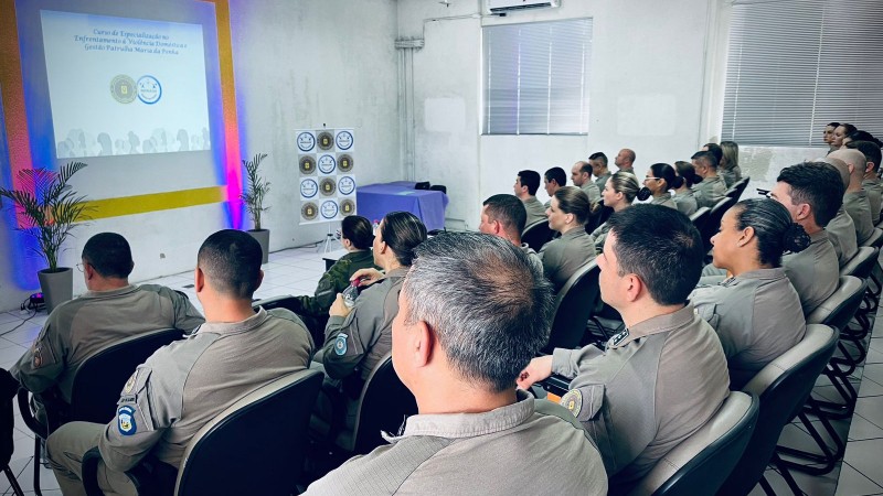 Foto mostra um auditório com oficiais sentados durante a formatura