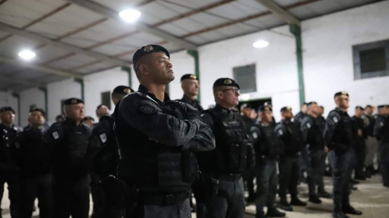 Foto mostra momento da concentração e preleção dos policiais militares, dentro de um galpão