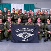 Foto mostra os formandos perfilados segurando uma bandeira do curso.