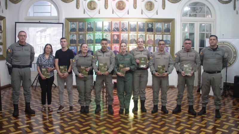 Foto mostra a comissão de elaboração do livro ladeada pelo Comandante-Geral da BM e o Chefe do Estado-Maior da BM