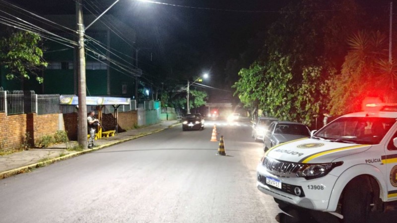Na imagem Rua Bento Gonçalves, viatura da Brigada Militar, cones de sinalização e veículos abordados na barreira policial
