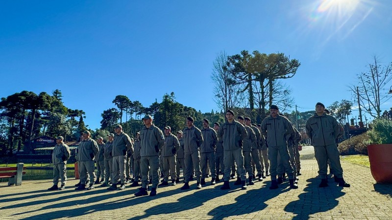 Efetivo da Brigada Militar no lançamento da Operação Inverno 2025 com araucárias ao fundo e céu azul ensolarado