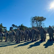 Efetivo da Brigada Militar no lançamento da Operação Inverno 2025 com araucárias ao fundo e céu azul ensolarado