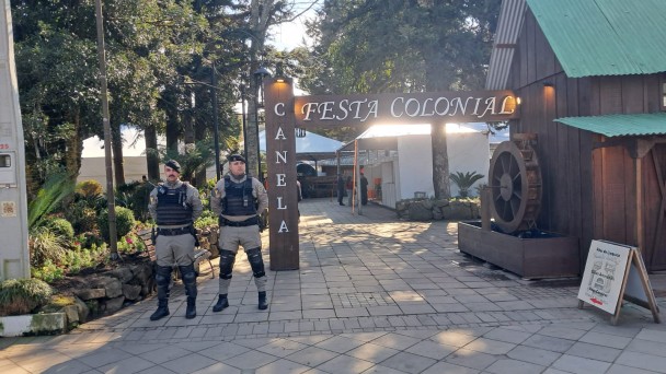 Dois policiais ao lado da entrada da Festa Colonial de Canela.