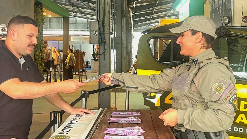 Policial da patrulha maria da penha entrega panfleto para civil