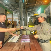 Policial da patrulha maria da penha entrega panfleto para civil 
