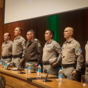 militares em fileira atrás de uma mesa, durante execução do Hino nacional