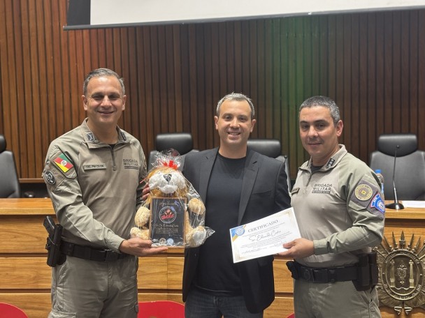 dois militares entregam certificado e símbolo do projeto ao palestrante da manhã