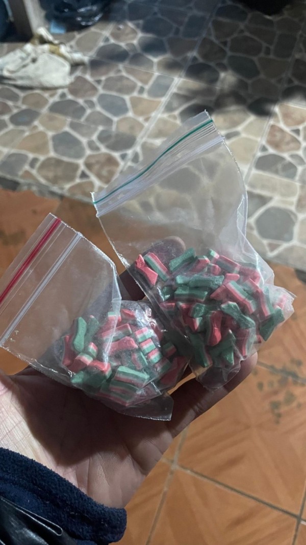 dois sacos plásticos, segurandos por uma pessoa, com comprimidos dentro