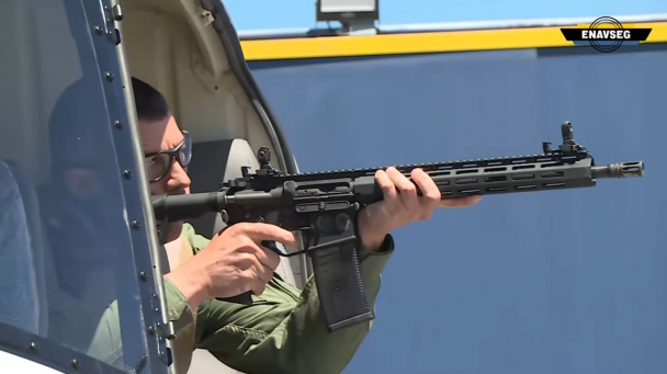 PM aparece mirando com uma arma de dentro de um helicóptero