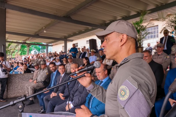 Subcomandante-geral fala ao púlpito diante do público presente. Ao fundo aparecem autoridades presentes, enrte elas, o governador Eduardo Leite e o secretário da Segurança Pública, Sandro Caron