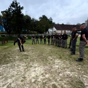 PMs em pé e em círculo assistindo uma técnica de projeção ao solo