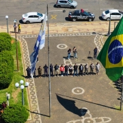 Imagem aérea mostra a fileira de autoridades em frente as bandeiras da Argentina e do Brasil.
