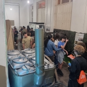 Diversos jovens entre os equipamentos antigos utilizados em guerras.