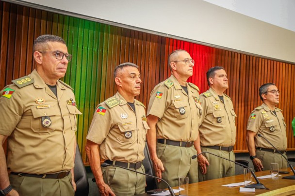 As autoridades que compuseran a mesa aparecem em pé durante o toque do Hino Nacional Brasileiro. 