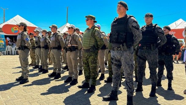 PMs aparecem enfileirados ma orla da praia. 