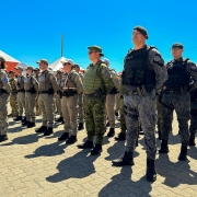 PMs aparecem enfileirados ma orla da praia. 