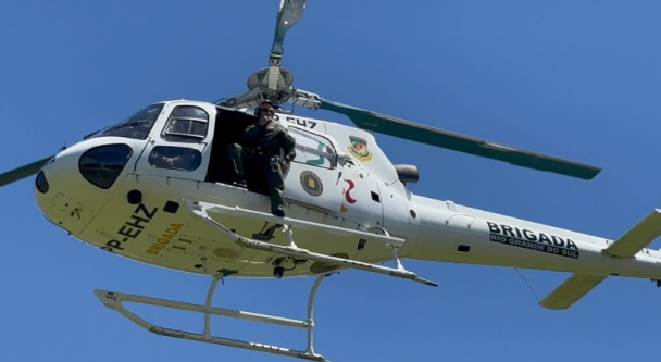 Helicóptero da BM em voo com PM visível. 