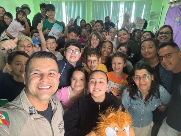 O PM aparece em selfie com a turma de estudantes na sala de aula. 