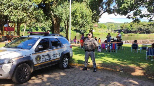 Viatura e PM aparecem em um ponto estrat&eacute;gico de uma &aacute;rea balne&aacute;vel no interior do Estado. Ao fundo aparece a &aacute;rea natural ocupada pelo p&uacute;blico. 