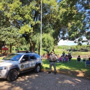 Viatura e PM aparecem em um ponto estrat&eacute;gico de uma &aacute;rea balne&aacute;vel no interior do Estado. Ao fundo aparece a &aacute;rea natural ocupada pelo p&uacute;blico. 