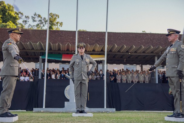 Foto mostra oficiais frente a frente segurando espadas em campo aberto durante passagem solene de subcomando da BM.