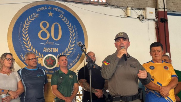 Foto mostra o coronel Martinelli, chefe do Estado-Maior da BM, com microfone no palco na abertura do event