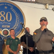 Foto mostra o coronel Martinelli, chefe do Estado-Maior da BM, com microfone no palco na abertura do event