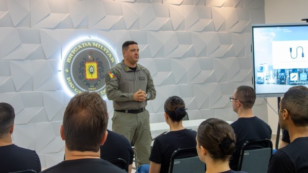 Foto mostra o comandante-geral da BM, coronel Luigi, em p&eacute;, em audit&oacute;rio, enquanto faz a apresenta&ccedil;&atilde;o