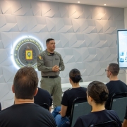 Foto mostra o comandante-geral da BM, coronel Luigi, em p&eacute;, em audit&oacute;rio, enquanto faz a apresenta&ccedil;&atilde;o