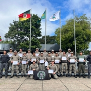 Imagem mostra os formandos reunidos em frente ao Batalh&atilde;o de Choque de Santa Maria segurando os seus diplomas do curso