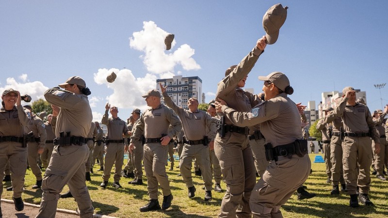 PMs abra&ccedil;am-se e festejam a formatura no campo do est&aacute;dio. 