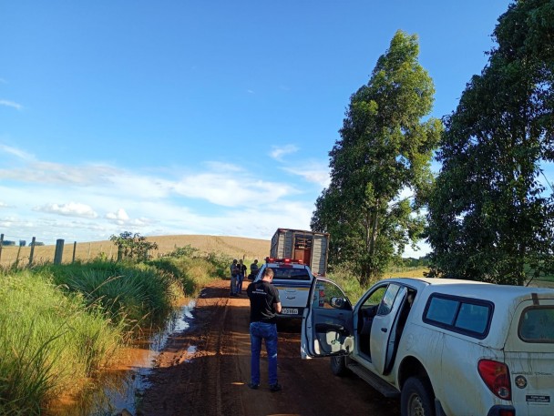 Viaturas das Polícias aparecem durante a abordagem a um caminhão em uma estrada de chão em área de lavoura. Algumas pessoas aparecem, entre elas as autoridades policiais. 